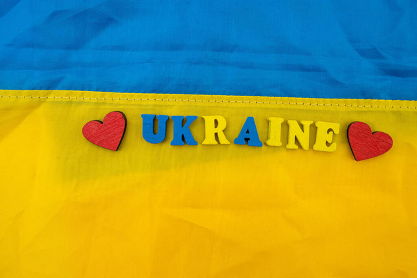 krásná ukrajinská vlajka modrá a žlutá a nápis kostky zastavit válku. Koncept ruské války s Ukrajinou. Sankce proti Ruské federaci - Fotografie, Obrázek