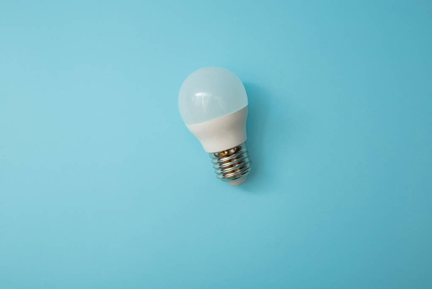 White light bulb on a blue background - Photo, Image