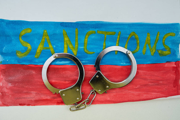 The inscription of the sanction on the flag of Russia for its attack on Ukraine, the people, children and the territory imposed sanctions. Economic sanctions against Russia and the Russian people - Foto, imagen