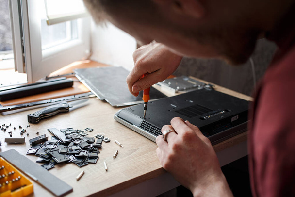 Чоловік самостійно ремонтує ноутбук, ремонт комп'ютера
 - Фото, зображення