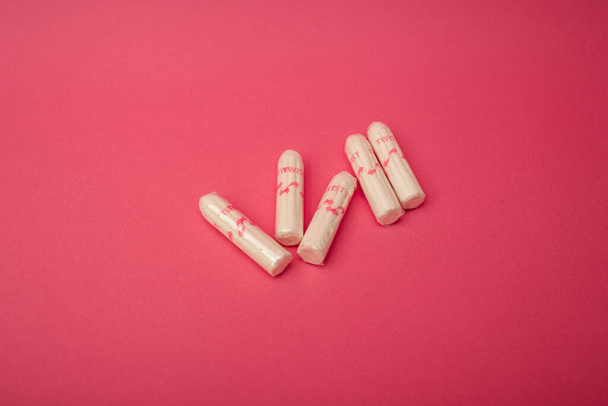 Medical female tampon on a pink background. Hygienic white tampon for women. Cotton swab. Menstruation, means of protection. - Photo, Image