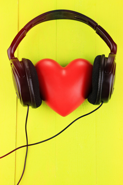 Headphones and heart on color wooden background - Фото, изображение