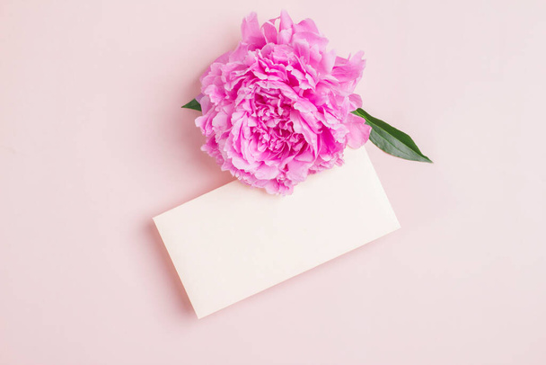 Einladungs- oder Grußkarten-Attrappe mit Umschlag und rosa holländischer Pfingstrose. - Foto, Bild