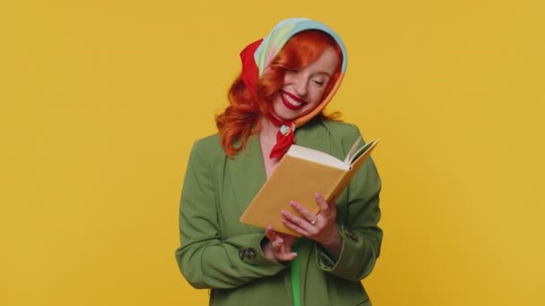 Vörös hajú fiatal nő olvas vicces érdekes mesekönyv, szabadidős hobbi, tudás bölcsesség, oktatás, tanulás, tanulás, wow. Piros haj gyömbér lány elszigetelt egyedül sárga stúdió háttér - Felvétel, videó
