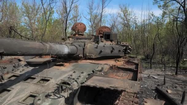 Vernietigde en uitgebrande tank van het Russische leger als gevolg van de strijd met Oekraïense troepen in het bos bij Kiev, Oekraïne. Russische agressie in Oekraïne. - Video