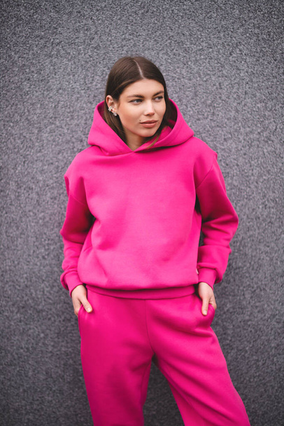 Portrait of a pretty oriental girl in a pink tracksuit. - Photo, image