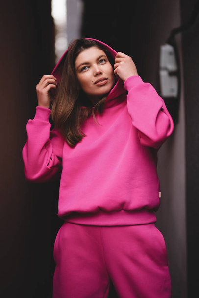Portrait of a pretty oriental girl in a pink tracksuit. - Photo, Image