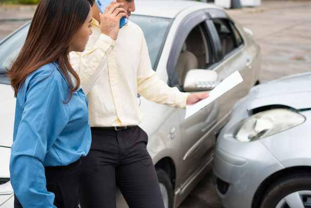 Zwei Autofahrer tauschen nach einem Autounfall per Smartphone Telefonnummern und soziale Medien aus. Konzept der Schadenversicherung für einen Autounfall online nach Zusendung von Foto und Beweisen an die Versicherung - Foto, Bild