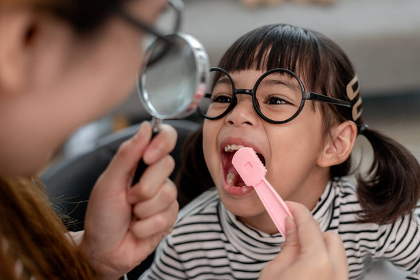 Schattig Aziatisch kind spelen met arts tandarts speelgoed set, kind laat zien hoe schoon te maken en zorg voor tanden. Tandheelkunde en geneeskunde, - Foto, afbeelding