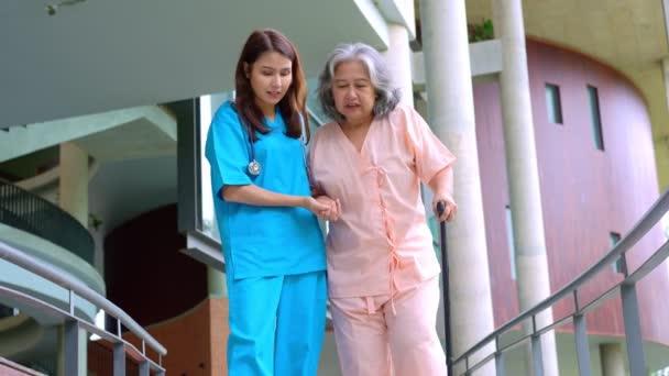 Mujer mayor asiática cayendo en el hospital causada por la miastenia (debilidad muscular) durante la terapia física y la enfermera vino a ayudar a apoyar. Concepto de seguro de vejez, atención médica y cuidador - Metraje, vídeo