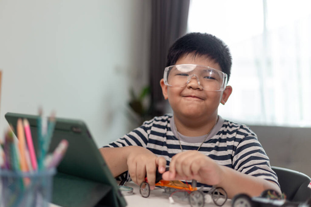 Юна азійська студентка дистанційно вчиться в Інтернеті в кодуванні машини робота і електронного настільного кабелю в STEM, STEAM, математичного інженера-інформаційного коду комп'ютера в робототехніці для дітей.. - Фото, зображення
