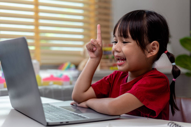 Aasialainen tyttö käyttää kannettavaa tietokonetta kotiopetukseen kotona karanteenin aikana. kotikoulu, verkko-opiskelu, kotikaranteeni, verkko-opiskelu, koronavirus tai opetusteknologian käsite - Valokuva, kuva