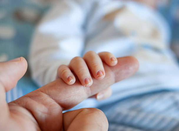 Yeni doğmuş bir bebeğin parmaklarının ayrıntıları, özellikle de tırnaklarının. Yeni doğan bebeklerin sinir uçlarıyla dolu uzun ve keskin tırnakları vardır.. - Fotoğraf, Görsel