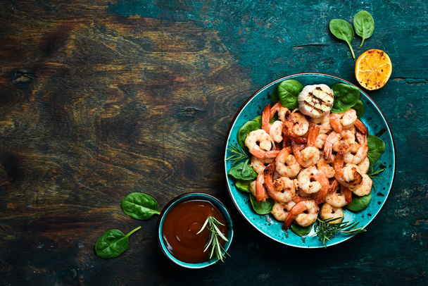 A plate of grilled shrimp with herbs, garlic and lemon. On a dark stone background. Top view. - Φωτογραφία, εικόνα
