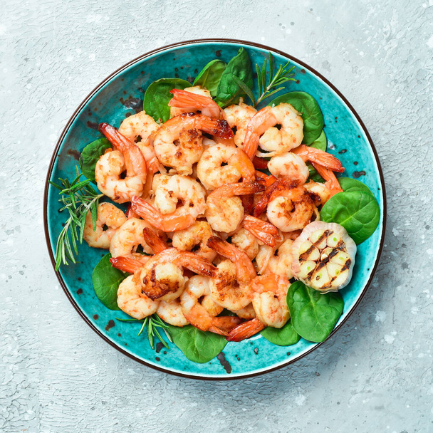Grilled shrimp served with lemon and sauce. Seafood on a plate. On a gray stone background. Top view. - Foto, Imagen
