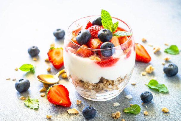 Parfait with cream or yogurt, jam and fresh berries in the glass jar. - 写真・画像