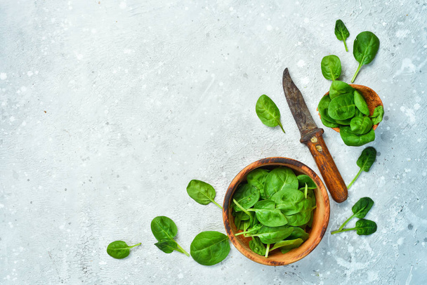 Green spinach leaves on a gray stone background. Healthy food. Top view. - Foto, Imagem