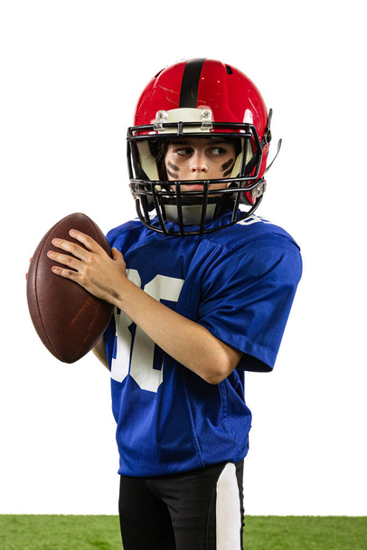 Future champion. Athletic kid, beginner american football player in sports uniform and helmet training isolated on white background. Concept of sport, challenges, action, achievements. - Photo, image