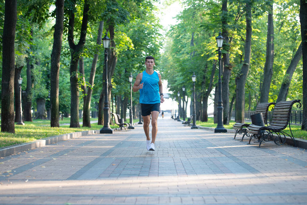 спортсмен бегущий в спортивной одежде на открытом воздухе. бег на дистанцию. - Фото, изображение