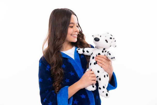Teen girl feeling relaxed in pajamas, good morning. Teenage girl embracing toy. Childhood, toys and kids. Cute teen girl cuddling favorite fluffy toy. Happy girl face, positive and smiling emotions - Foto, Imagem