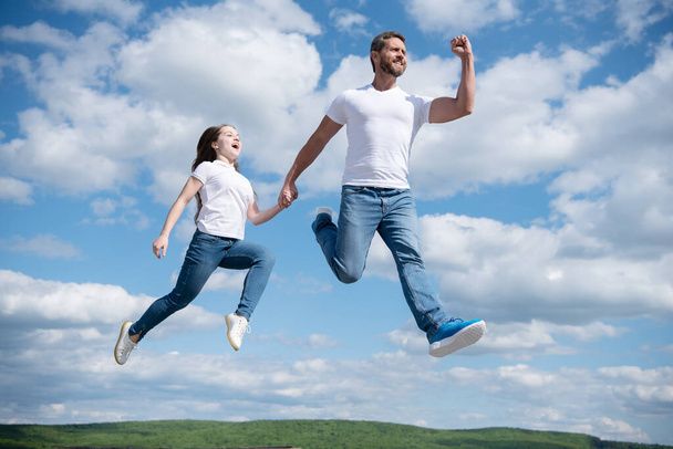 glücklicher Vater und Tochter springen in den Himmel. Freundschaft. - Foto, Bild