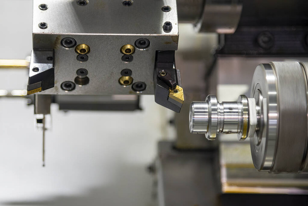 La máquina de torno CNC de doble husillo que forma el corte de las piezas del eje de metal. El procesamiento de mecanizado de metales de alta tecnología por máquina de torneado CNC . - Foto, Imagen