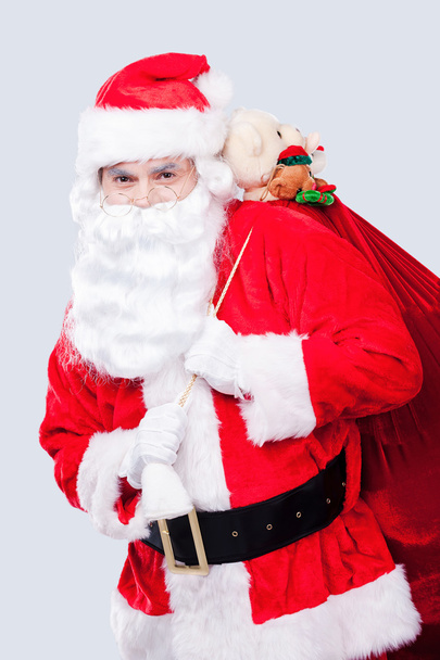 Santa Claus carrying sack with presents - Foto, immagini