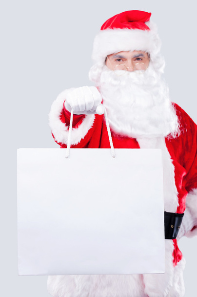 Santa Claus strekken hand met boodschappentas - Foto, afbeelding