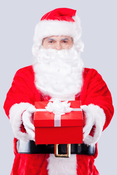 Papai Noel esticando caixa de presente
 - Foto, Imagem