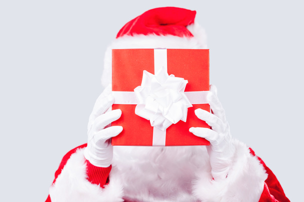 Babbo Natale nasconde il suo volto dietro la scatola regalo
 - Foto, immagini