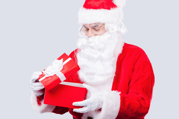 Weihnachtsmann hält Geschenkbox in der Hand - Foto, Bild