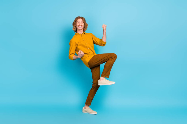 Full size photo of cheerful excited crazy male raise fists in vicotry triumph win money prize isolated on blue color background. - Foto, afbeelding