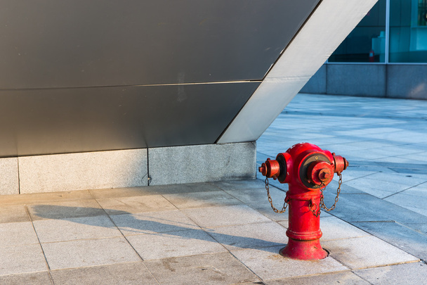 Hidrante de ligação vermelha debaixo da escada
 - Foto, Imagem
