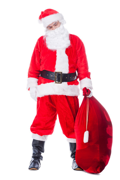 Santa Claus carrying sack with presents - Фото, изображение