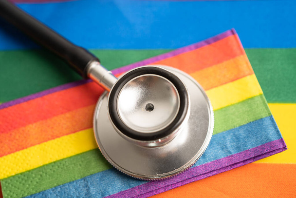 Stetoscopio nero con cuore bandiera arcobaleno su sfondo bianco, simbolo del mese dell'orgoglio LGBT celebrare annuale nel mese di giugno sociale, simbolo di gay, lesbiche, bisessuali, transgender, diritti umani e pace. - Foto, immagini