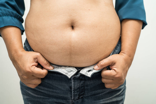 Excesso de peso mulher asiática mostrar barriga gorda no escritório. - Foto, Imagem