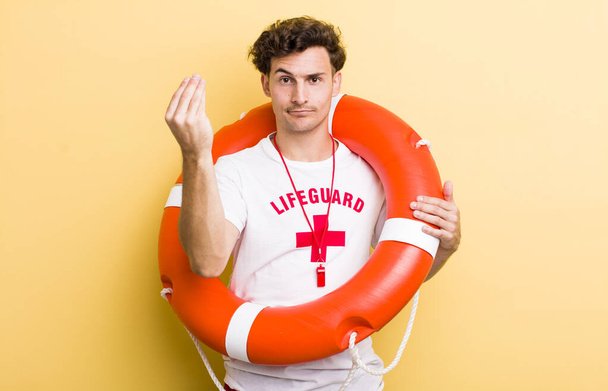 young handsome guy making capice or money gesture, telling you to pay. lifeguard concept - Foto, immagini