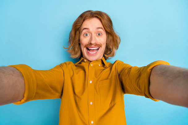 Self-portrait of attractive cheerful long-haired guy having fun good mood isolated over bright blue color background. - Fotoğraf, Görsel