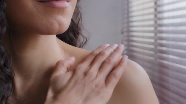 Крупним планом знімок невідомої чуттєвої сексуальної молодої іспаномовної жінки, що наносить крем поваги на оголене плече, насолоджуючись повсякденною косметикою, спа-процедури лікують шкіру органічним лосьйоном, застосовуючи зволожувач
 - Кадри, відео