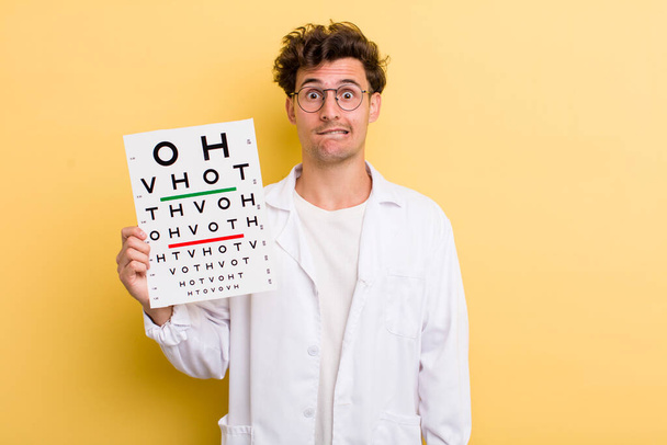 young handsome guy looking puzzled and confused. optical vision test concept - Foto, Imagem