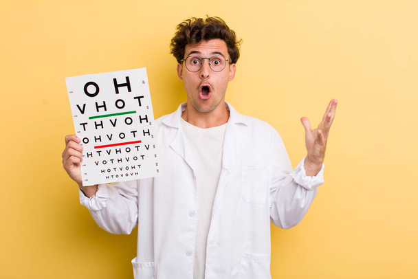 young handsome guy feeling extremely shocked and surprised. optical vision test concept - Foto, Imagem