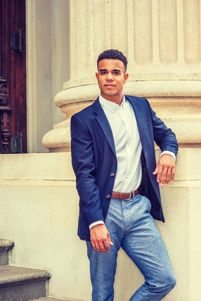 Afro-Amerikaanse zakenman werkt in New York. Blauwe blazer, wit shirt, grijze broek, een zwarte student die buiten op de campus op je wacht..  - Foto, afbeelding