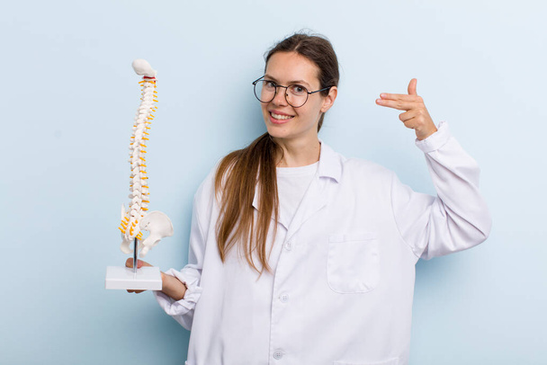 young adult woman smiling confidently pointing to own broad smile. spine specialist concept - Photo, Image