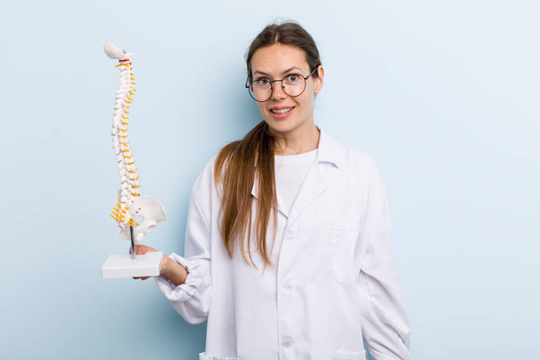 young adult woman looking happy and pleasantly surprised. spine specialist concept - Fotó, kép