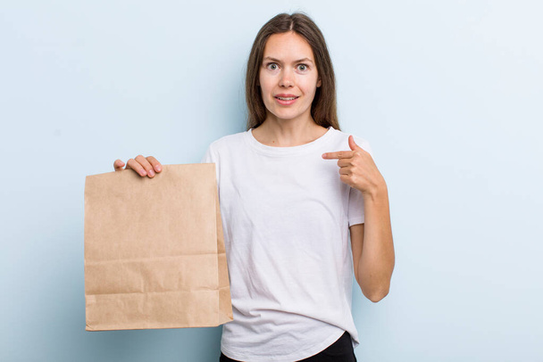 young adult woman feeling happy and pointing to self with an excited. delivery and take away concept - Photo, image