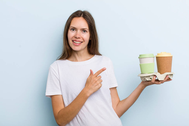 young adult woman looking excited and surprised pointing to the side. take away coffee concept - Photo, Image