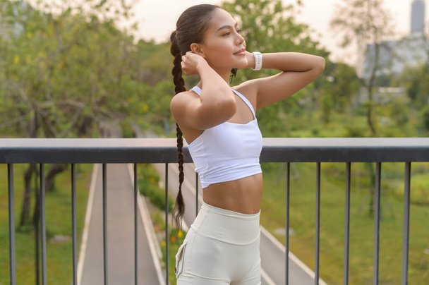 A portrait of young fitness woman in sportswear in city park, Healthy and Lifestyles. - 写真・画像