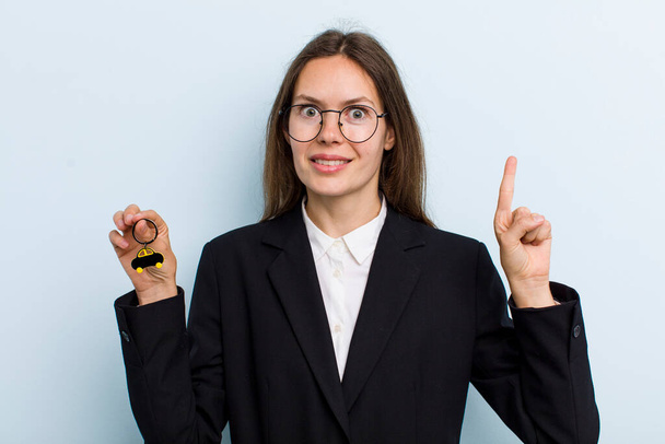 young adult woman smiling and looking friendly, showing number one. bitcoin concept - Foto, Bild