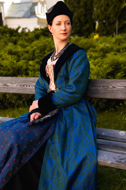Retrato de mujer vestida con ropa barroca histórica azul con peinado de moda antigua, al aire libre. Lujoso vestido medieval - Foto, imagen