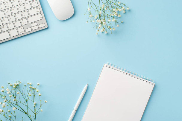 Business concept. Top view photo of workstation keyboard computer mouse open notepad pen and white gypsophila flowers on isolated pastel blue background with blank space - Photo, Image